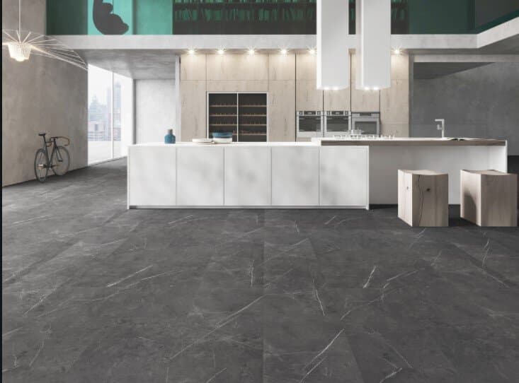 Dark stone flooring with natural veining in an open-plan loft kitchen